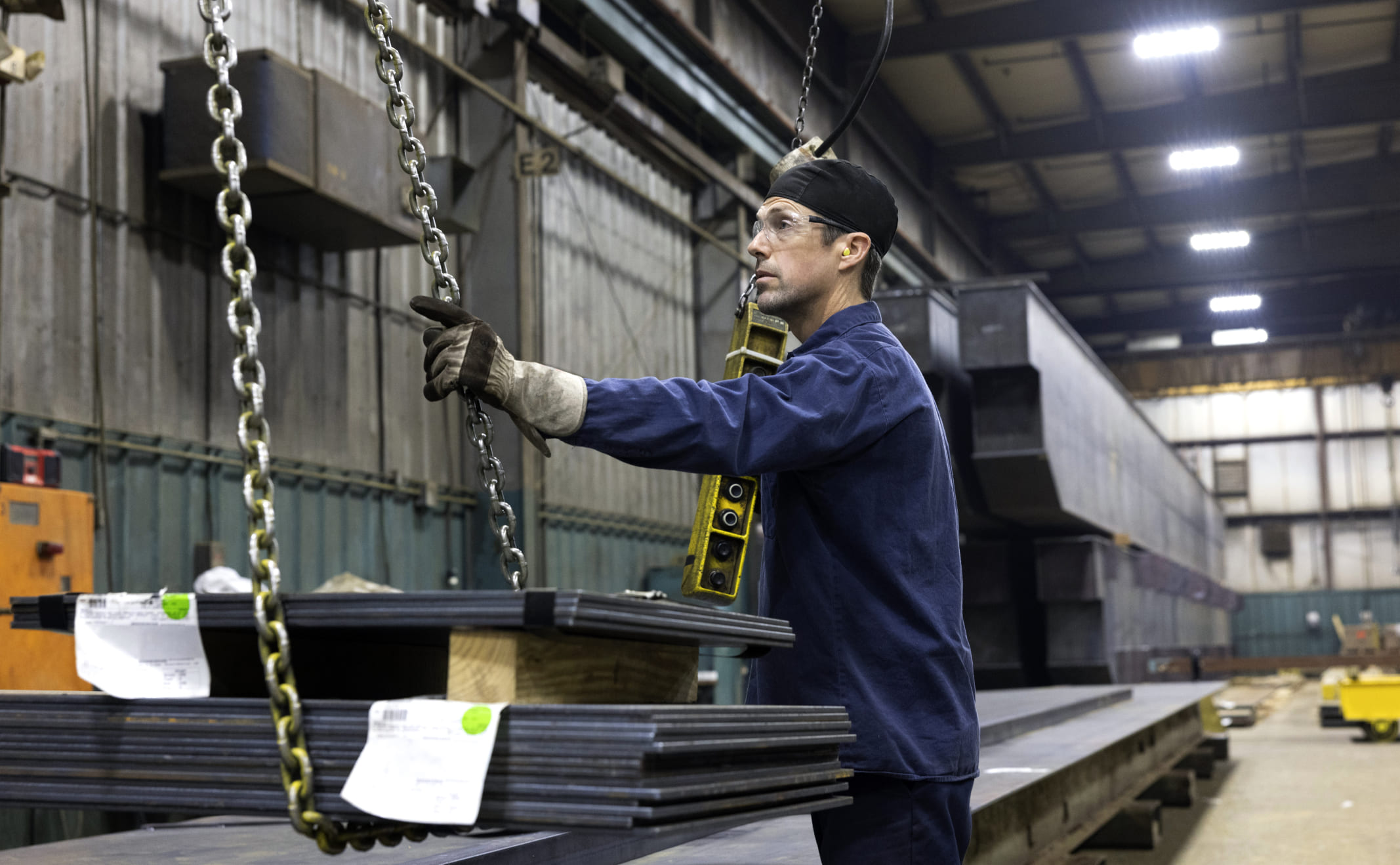 Zenar employee moving sheet metal hanging from chain